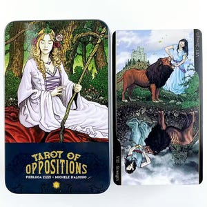 May include: A tarot card deck in a metal tin. The tin features a woman in a white dress with a staff. The deck includes cards with illustrations of figures and animals, including a lion and a woman. The text "Tarot of Oppositions" is visible.