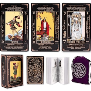 May include: A tarot card deck set featuring three illustrated cards labeled The Fool, The Magician, and The High Priestess with black borders and gold text. Includes a matching storage box, a card back design, an instruction booklet, and a purple pouch.