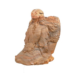 Puede incluir: Una escultura de ángel de piedra arenisca con alas, tallada en un patrón de capas y rayas de color marrón, naranja y blanco.