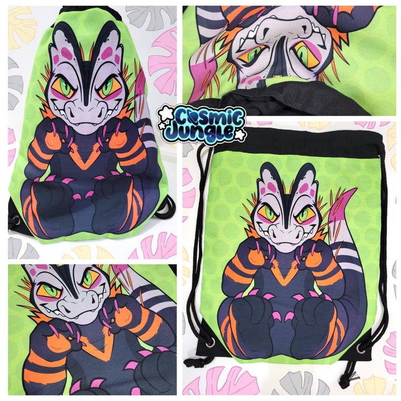 May include: A green drawstring bag with a black and pink cartoon dinosaur with orange stripes. The dinosaur is sitting with its arms crossed and has a menacing expression. The bag has the text "Cosmic Jungle" printed on it.