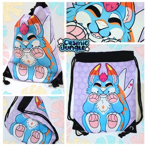 May include: A drawstring bag with a colorful cartoon character on it. The character is a blue and orange furry creature with a pink nose and white eyes. The bag is purple with white polka dots. The text "Cosmic Jungle" is on the bag.