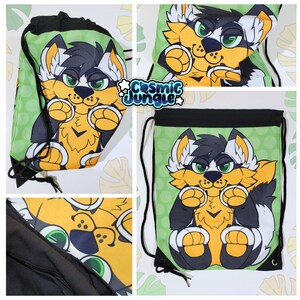May include: A green drawstring bag with a black and white furry creature with yellow accents. The creature is holding its paws up to its face. The bag has a white polka dot pattern and the text "Cosmic Jungle" in white letters.