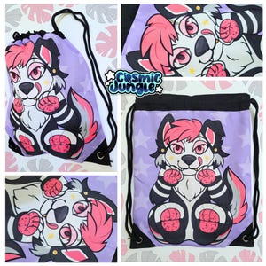 May include: Purple drawstring bag with a white furry creature with pink hair and black and white stripes. The creature has a pink nose and black eyes. The bag has a white star pattern.