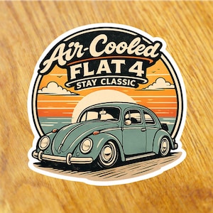 Könnte beinhalten: Aufkleber mit einer Illustration eines tealfarbenen Oldtimers und dem Text "Air-Cooled FLAT 4 STAY CLASSIC". Das Design zeigt einen Sonnenuntergang in Orange, Gelb und Blau, mit einem weißen Rand.