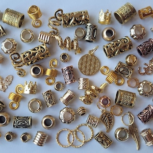 Peut inclure: Un assortiment de perles et de breloques de cheveux en métal doré. La collection comprend diverses formes, telles que des perles cylindriques, des spirales et des breloques décoratives avec des motifs et des dessins complexes. Différentes tailles sont présentes.