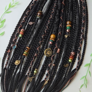 Peut inclure: Dreadlocks synthétiques noirs avec des perles et des breloques brunes, vertes et dorées. Les dreadlocks sont attachées ensemble avec un élastique noir.