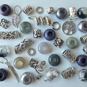 Puede incluir: Una colección de 30 cuentas para el cabello en varios estilos y colores, incluyendo plata, morado y gris. Las cuentas están hechas de metal, piedra y vidrio. Algunas cuentas presentan diseños intrincados, mientras que otras son simples y elegantes.