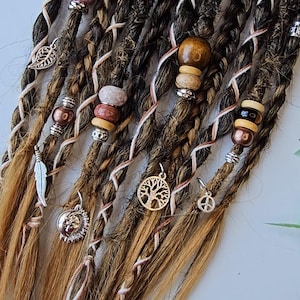 May include: A set of brown and blonde synthetic dreadlocks with various beads and charms, including a tree of life pendant, a peace sign charm, and a feather charm.
