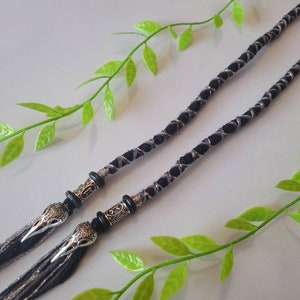 May include: Two black and silver braided cords with silver bird head charms at the ends.