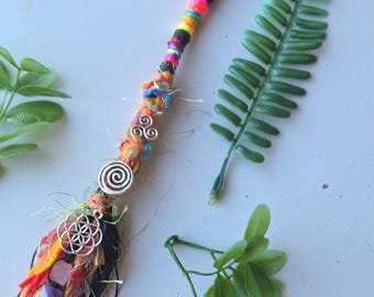 Regnbågsfärgad hårförlängning med dreadlocks. 7 kristaller och 3 spiralberlocker. Dreadlock-tillbehör i hippiestil.