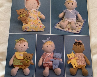 May include: A sewing pattern for making dolls. The pattern includes instructions for making a baby doll with a bonnet, a baby doll with a diaper and a shirt, and a baby doll with a dress. The pattern is from Simplicity and is for one size.