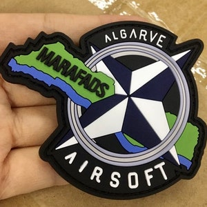 Può includere: Toppa nera e verde con un design a bussola e il testo "ALGARVE MARAFADS AIRSOFT".
