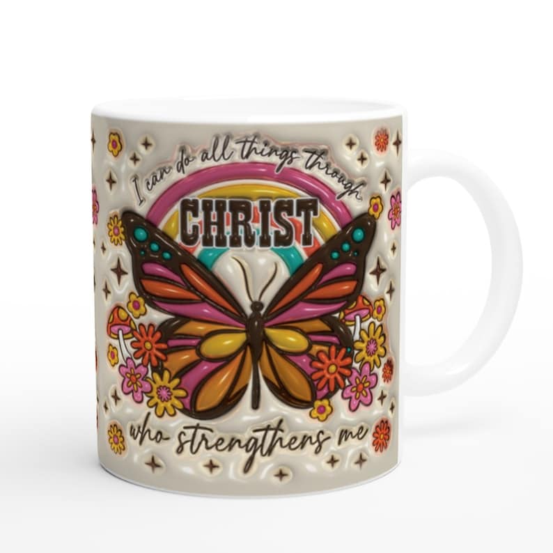 Op de afbeelding: Witte keramische mok met een kleurrijk vlinderontwerp en de tekst "Ik kan alles door CHRISTUS doen die mij kracht geeft".