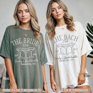 May include: Two oversized t-shirts with a hen party theme. The green shirt says "The Bride Club" with a line drawing of three martini glasses and the text "Est. 2025 Emily's Bachelorette Nashville, TN". The white shirt says "The Bach Club" with a line drawing of three martini glasses and the text "Est. 2025 Emily's Bachelorette Nashville, TN".