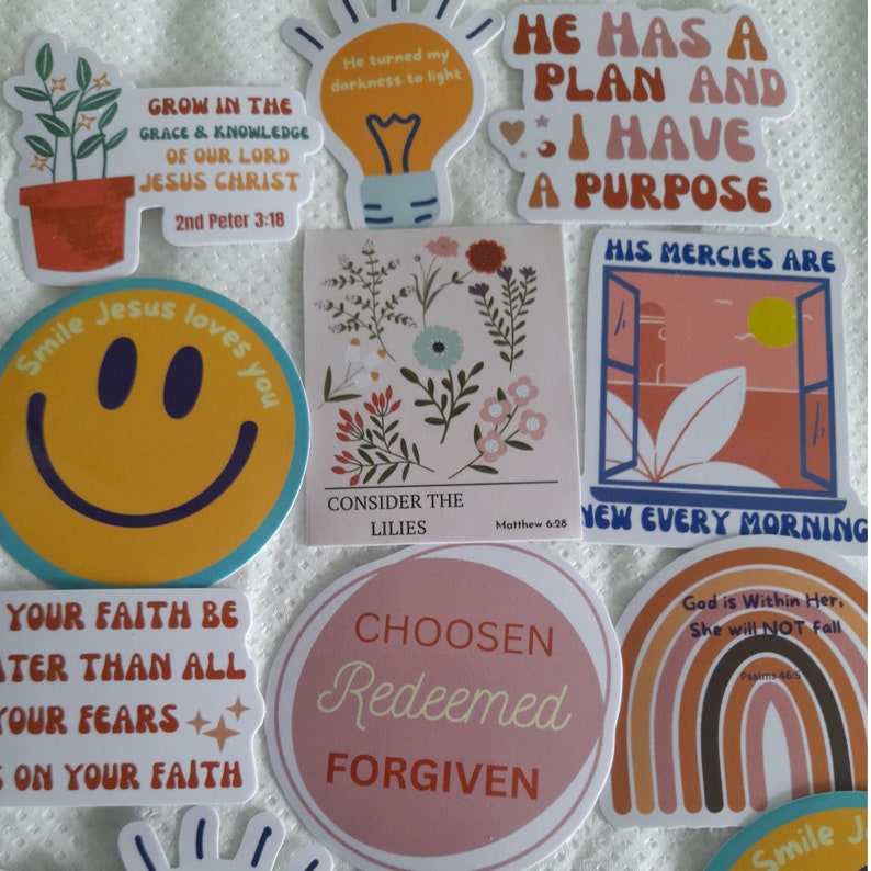 May include: A collection of colorful stickers with inspirational quotes and bible verses. The stickers feature a variety of designs, including flowers, a smiley face, a lightbulb, a rainbow, and a window.