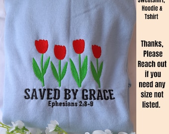 Puede incluir: Sudadera azul claro con tulipanes rojos bordados y el texto "SAVED BY GRACE Ephesians 2:8-9".