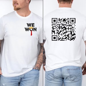 Può includere: Maglietta bianca con il testo "WE WON" e una cravatta rossa sul davanti. La parte posteriore della maglietta ha un codice QR in bianco e nero.