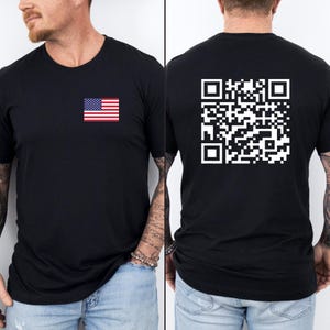 Peut inclure: T-shirt noir avec un petit drapeau américain imprimé sur le devant et un code QR imprimé au dos.