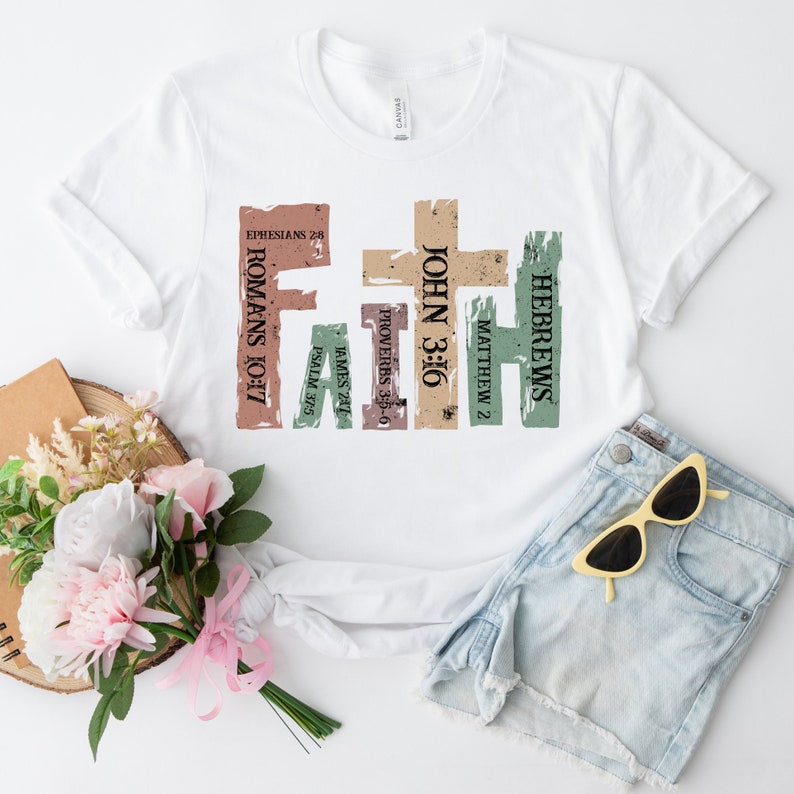May include: White t-shirt featuring the word "FAITH" in a colourful, vertical design. The design includes Bible verses such as Romans 10:17 and John 3:16. The shirt is paired with denim shorts and sunglasses, with a bouquet of flowers.