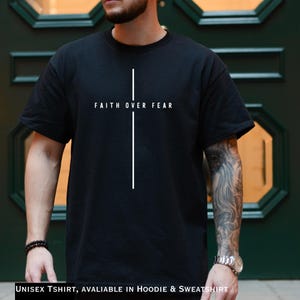 May include: Black unisex t-shirt featuring the words "FAITH OVER FEAR" and a white cross. The short-sleeved shirt is made of a soft material. Available in hoodie and sweatshirt styles.