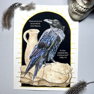 May include: A watercolour painting of a raven perched on a rock with a clay jug beside it. The raven has blue and black feathers. The background is black with a gold halo around the raven and jug. The text "Drink from the brook and eat what the ravens bring you, for I have commanded them to bring you food." 1 Kings 17:4 is written in white text.