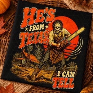 May include: A black graphic print featuring a skull-faced figure in an apron holding a chainsaw. The text reads HE'S FROM TEXAS, I CAN TELL. The background shows a farmhouse, a windmill, and a large orange sun, all rendered in a retro style.