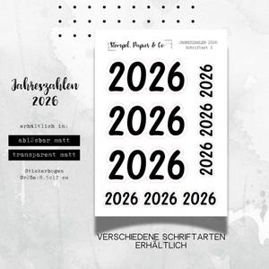 Könnte beinhalten: Ein Bogen Aufkleber mit der Zahl "2026" in fetter, schwarzer Schrift. Die Aufkleber sind in matter und transparenter Ausführung erhältlich. Der Bogen misst 8,5 x 12 cm.