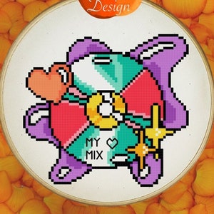 May include: A cross-stitch design of a pixelated bunny with a heart, key, and the text "MY MIX" within an embroidery hoop. The design is surrounded by orange flower petals, with the "Orange Potato Design" logo at the top.