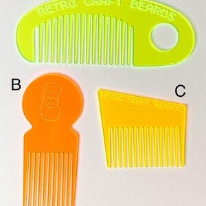 May include: Three different beard combs, one yellow, one orange, and one yellow. The yellow combs have the text "Retro Craft Beards" on them. The orange comb has a pixelated image of a bearded man on it.