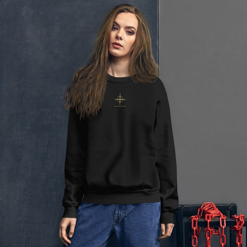 May include: Black sweatshirt with a gold cross and the text "remarkable ordinary" on the front.