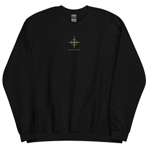 May include: Black sweatshirt with a gold crosshair design on the front.