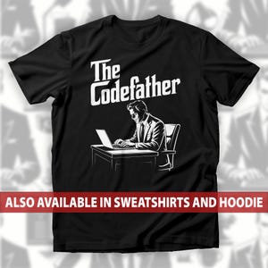 Può includere: T-shirt nero con la scritta "The Codefather" in bianco. La grafica raffigura un uomo in giacca e cravatta che lavora su un computer portatile. La parte inferiore della maglietta riporta la scritta "ALSO AVAILABLE IN SWEATSHIRTS AND HOODIE".