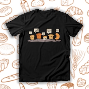 Puede incluir: Una camiseta negra con un gráfico de diferentes tipos de pan con refranes divertidos. El texto dice "Me encantan los juegos de palabras", "Levántate y brilla, soy una masa madre", "Córtate en una parrilla", "Levántate y brilla, nunca te pongas moho", "Soy el único que es un croissant".