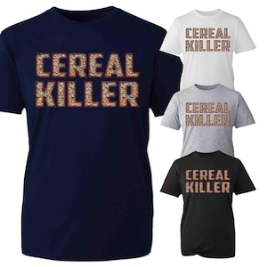 May include: A collection of short-sleeved t-shirts in navy blue, white, gray, and black. Each shirt features the text "CEREAL KILLER" in a colorful, textured font, resembling cereal pieces.