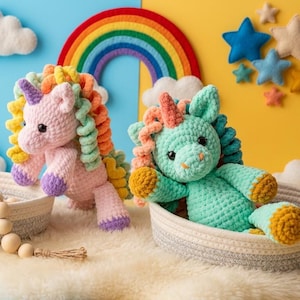 May include: Two crocheted unicorn plush toys, one pink and one teal, with rainbow manes and purple hooves, sit in woven baskets. A rainbow and felt clouds decorate the background. The scene is set on a fluffy white surface.