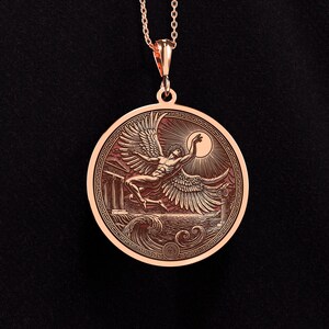 May include: Rose gold pendant necklace featuring a detailed relief of a winged figure reaching for the sun, set against a backdrop of waves and classical architecture. The pendant is round with an intricate border and hangs from a delicate chain.