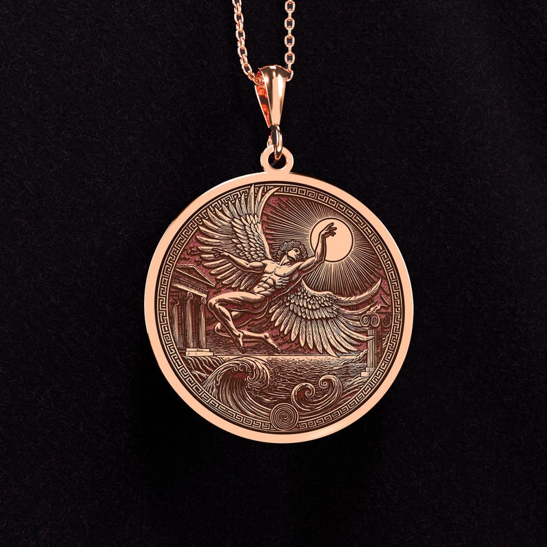 May include: Rose gold pendant necklace featuring a detailed relief of a winged figure reaching for the sun, set against a backdrop of waves and classical architecture. The pendant is round with an intricate border and hangs from a delicate chain.