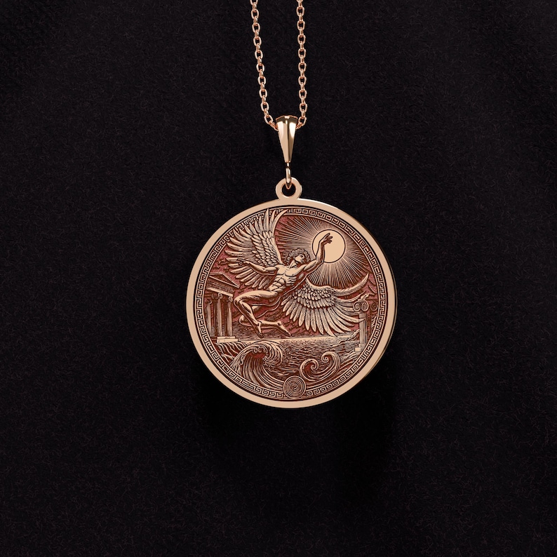 May include: A rose gold pendant necklace featuring a detailed relief of a winged figure reaching for the sun. The circular pendant has an intricate border design and is suspended from a delicate chain. The design includes architectural elements and waves.