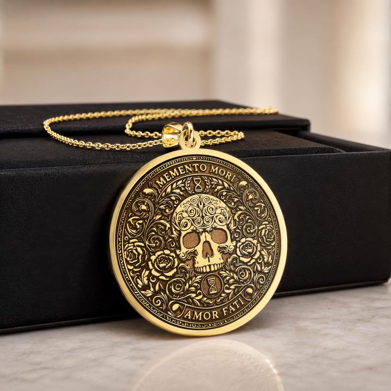 Detailed view of the Latin inscriptions Memento Mori above the skull and Amor Fati below it with engraved hourglass symbols.