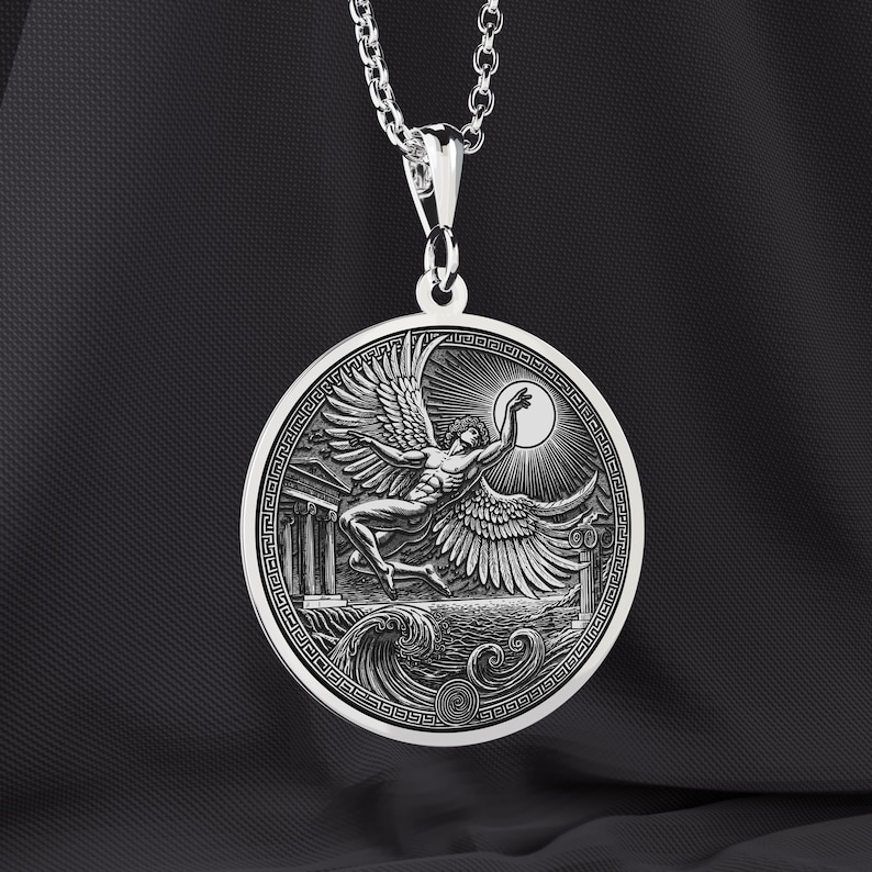 May include: A silver pendant necklace featuring a detailed relief of a winged figure reaching towards a sun, set against a backdrop of waves and classical architecture. The pendant is round with a decorative border and hangs from a silver chain.