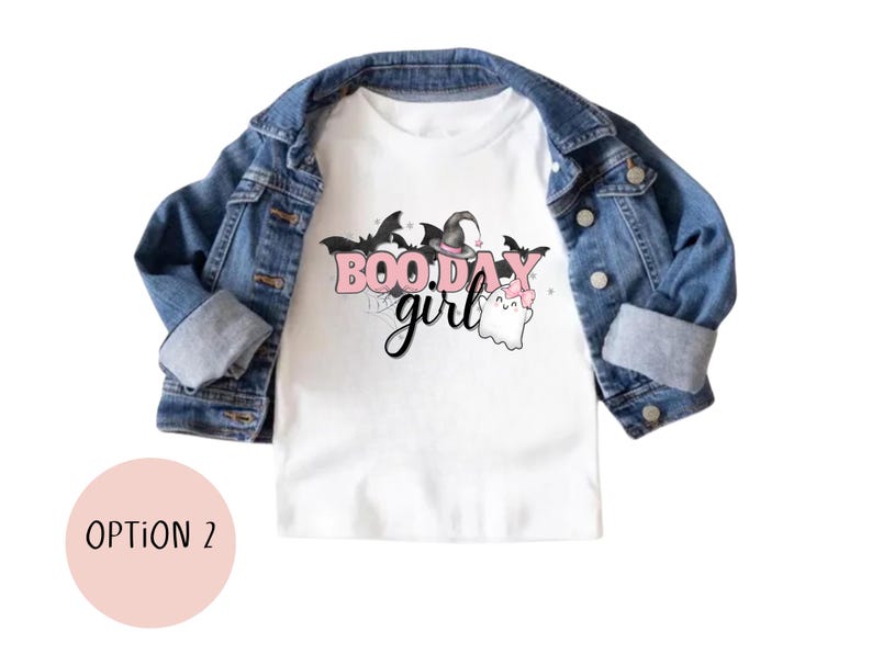 May include: White t-shirt with a pink and black graphic that says "Boo Day Girl" with a ghost and witch hat.