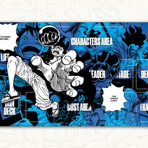 May include: A blue and black game mat with a cartoon image of a character from the anime One Piece. The mat has sections labeled "Characters Area", "Leader", "Damage", "Deck", "Cost Area", "Dun Deck", and "Trash".