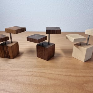 Könnte beinhalten: Eine weiße Keramik-Tasse mit schwarzem Henkel und dem Text "But First, Coffee" in schwarzer, fetter Schrift. Die Tasse steht auf einer Holzoberfläche.