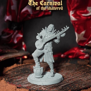 May include: A grey miniature figure of a musician playing a stringed instrument. The figure stands on a circular base, with the text "The Carnival of the Shattered" above. Red and white fabric is in the background.