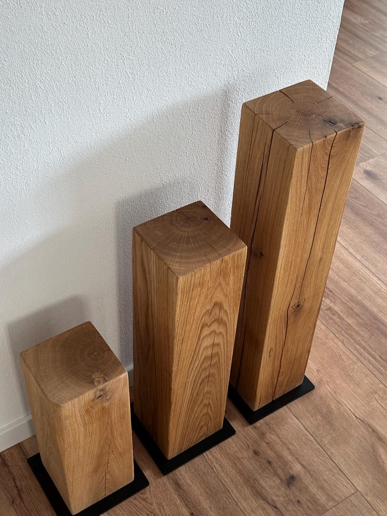 May include: Three wooden blocks of varying sizes, each with a natural wood finish and a dark brown base. The blocks are arranged in a row from smallest to largest.