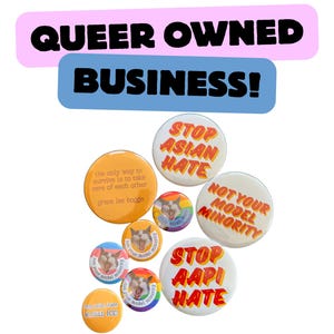 May include: A collection of round buttons with various designs and text. The buttons include phrases like "STOP ASIAN HATE" and "NOT YOUR MODEL MINORITY." The image also features text that reads "QUEER OWNED BUSINESS!"