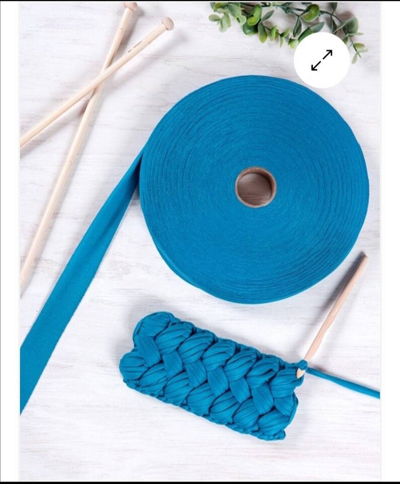 May include: A roll of teal blue fabric yarn with wooden knitting needles and a crocheted teal blue fabric pouch.