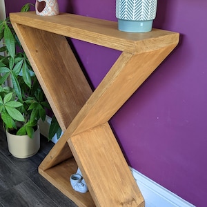 Puede incluir: Una taza de cer&aacute;mica blanca con un asa negra y el texto "But First, Coffee" en negro, con una fuente de estilo manuscrito. La taza est&aacute; sobre una superficie blanca. La taza mide aproximadamente 10 cm de alto.