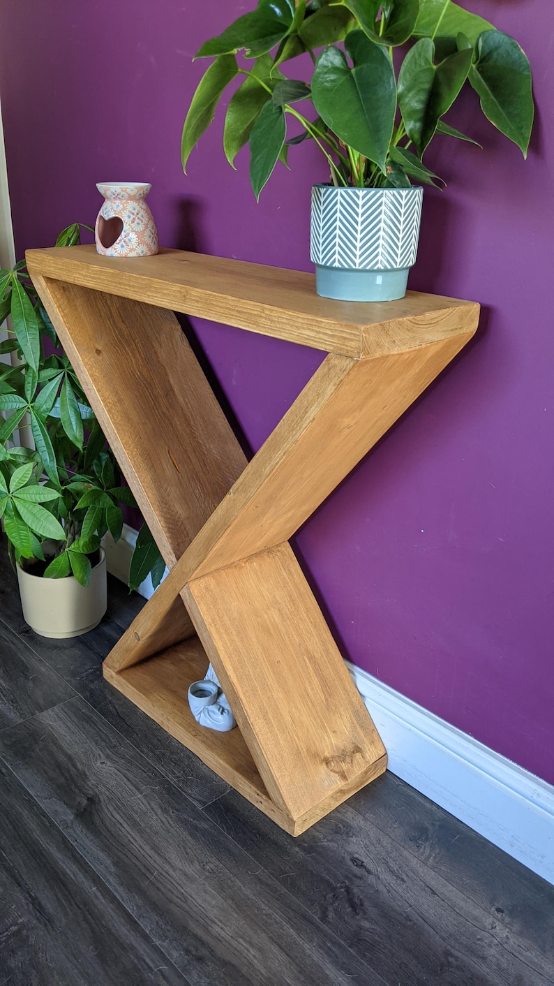 Puede incluir: Una taza de cer&aacute;mica blanca con un asa negra y el texto "But First, Coffee" en negro, con una fuente de estilo manuscrito. La taza est&aacute; sobre una superficie blanca. La taza mide aproximadamente 10 cm de alto.