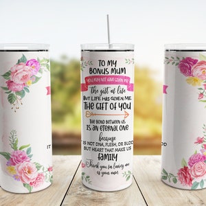 Puede incluir: Un vaso aislado blanco con un dise&ntilde;o floral y el texto "TO MY BONUS MUM". El vaso presenta flores rosas y amarillas y una pancarta rosa. Incluye una pajita y est&aacute; dise&ntilde;ado para bebidas fr&iacute;as.